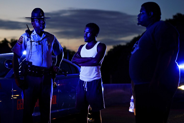 Image: Two protesters speak with a Georgia State Patrol officer after taking over and blocking a freeway during a rally against racial inequality and the police shooting death of Rayshard Brooks, in Atlanta