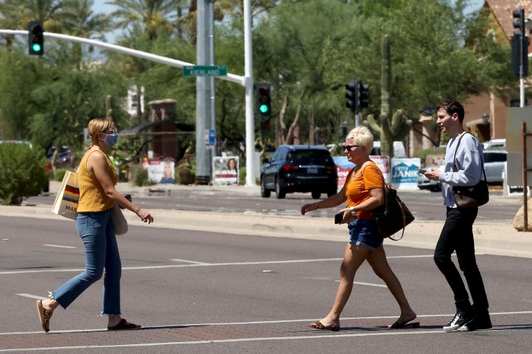 Image: People cross the street between Kierland Commons and Scottsdale Quarter with and without face coverings, during the global outbreak of the coronavirus disease (COVID-19), in Scottsdale