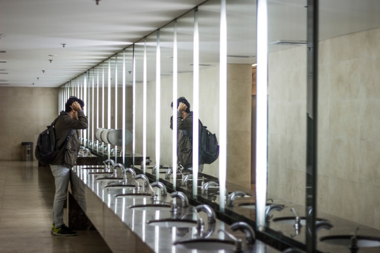 Side View Of Man Standing In Public Restroom