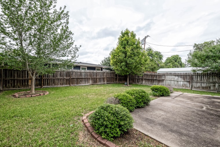 The roomy backyard has plenty of space for outdoor activities. 