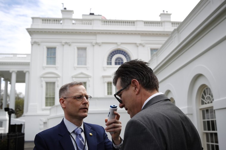 Image: A member of the White House physicians office takes the temperature of a member of the media on March 21, 2020.