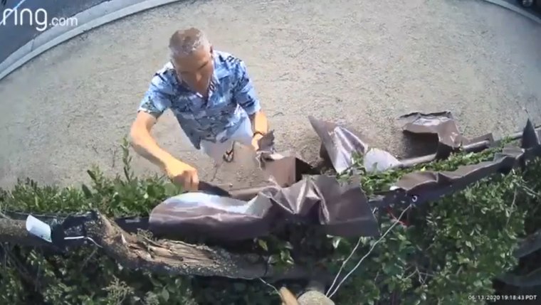 Darrin Stone on camera using a knife to take down a sign hung from a homeowner's fence facing Westlake Boulevard in Thousand Oaks, Calif.