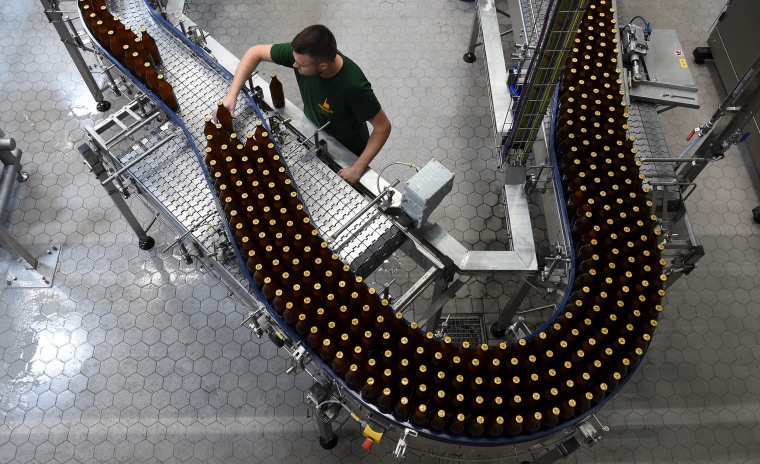Image: Employee Maximilian Henkies checks the process of a newly set up bottling plant of a brewery in Munich, southern Germany