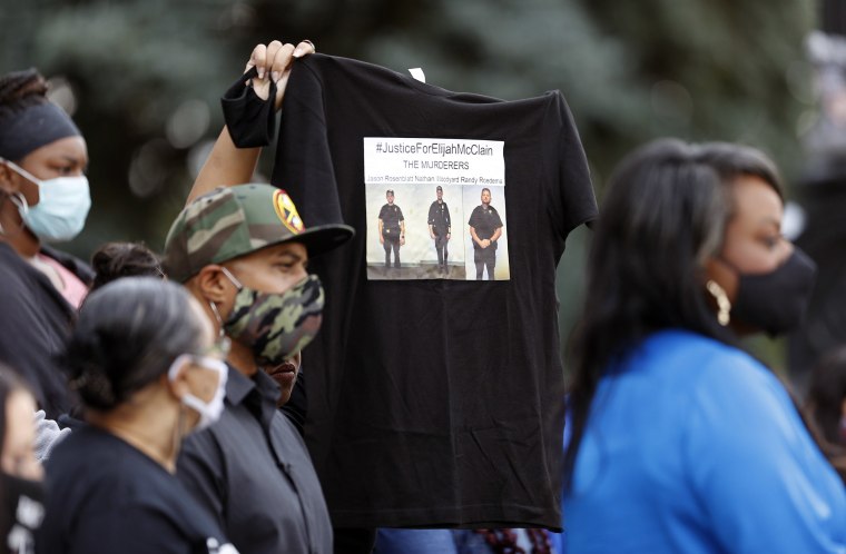 Image: A supporter holds up a shirt to call attention to the death of Elijah McClain in Aug. 2019 in Aurora, Colo