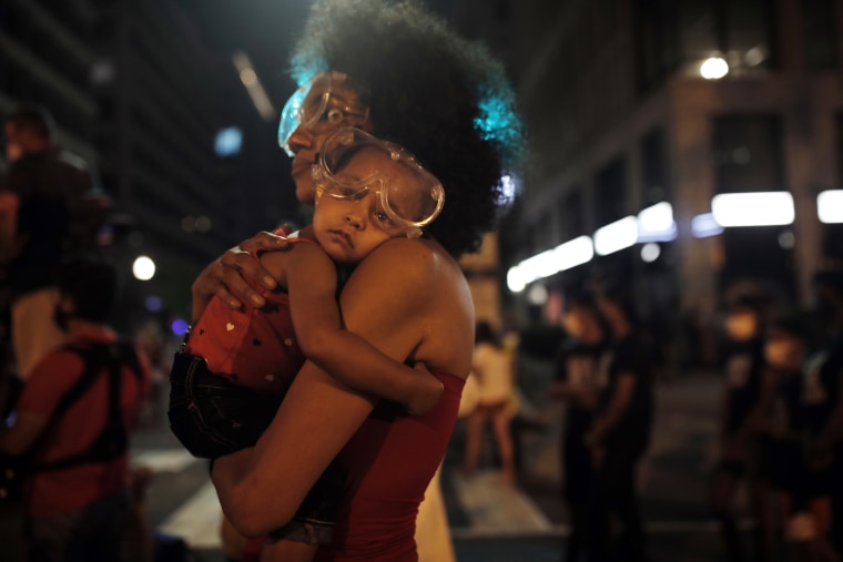 A sleepy Bonita wears protective goggles as she settles into her mother's shoulder during a protest near the White House on June 23.