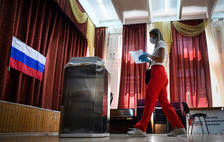 Image: A woman wearing a face mask and gloves walks to cast her ballot in a nationwide vote on constitutional reforms at a polling station in Moscow