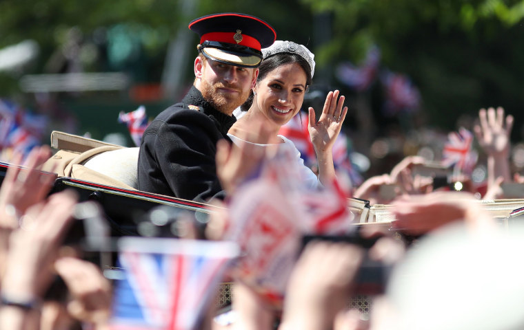 Image: Britain's Prince Harry, Duke of Sussex and his wife Meghan, Duchess of Sussex wave from the Ascot Landau Carriage during their carriage procession on the Long Walk as they head back towards Windsor Castle