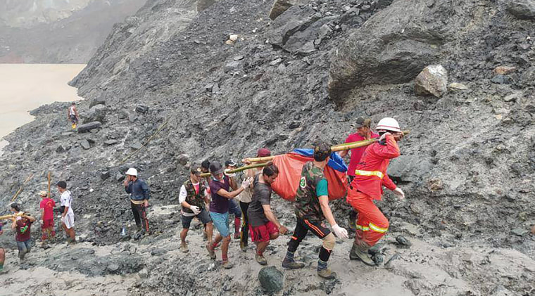 Image: Rescuers carry a recovered body of a victim of a landslide from a jade mining area in Hpakant, Kachine state, northern Myanmar