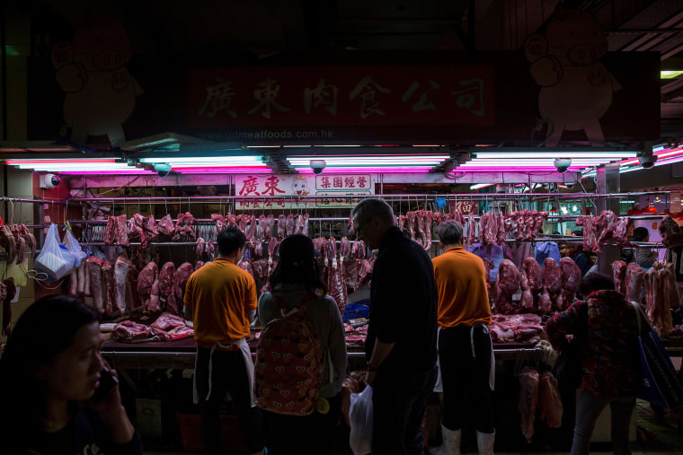 Image: Customers purchase pork from a stall at the Wan Chai wet market in Hong Kong.