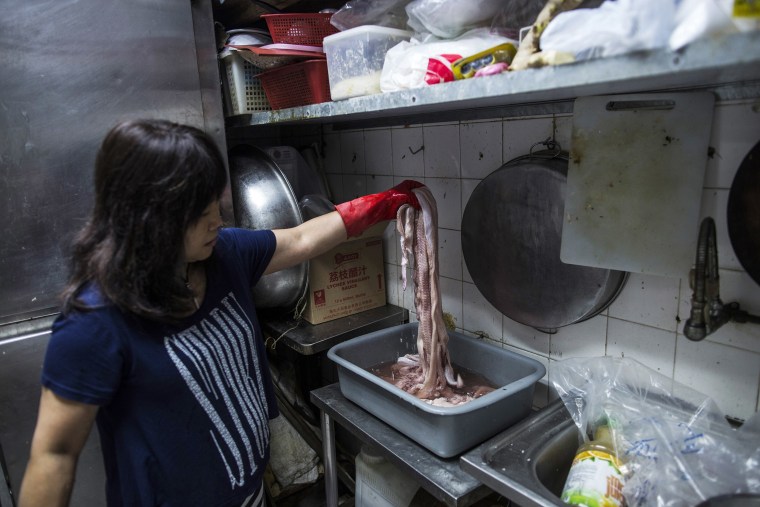 Image: Chow Ka-ling, owner of Shia Wong Hip snake restaurant, handles snake meat in the restaurant's kitchen in the Sham Shui Po district of Hong Kong, China.