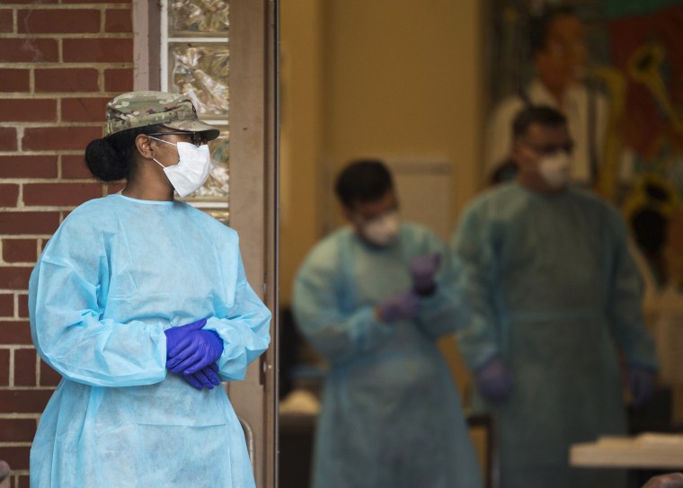 A member of the Tennessee National Guard Medical Staff stands outside the East Lake Courts Community Center, where free COVID-19 testing was offered in Chattanooga, Tenn. in May.