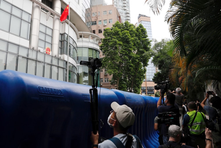 Image: A journalist takes video through water filled barriers after the opening ceremony of a temporary national security office, in Hong Kong