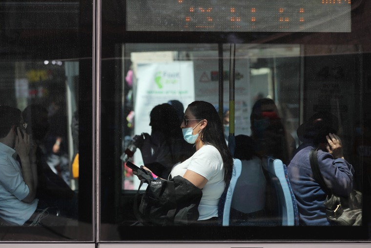 Image: Passengers, one wearing a protective mask, are seen through the windows of the light rail in Jerusalem amid the spread of the coronavirus disease (COVID-19)