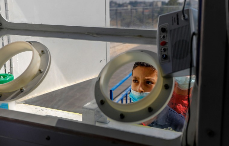 Image: A Palestinian child prepares to get checked for coronavirus at a mobile testing station in Sheikh Jarrah, Jerusalem on Monday.