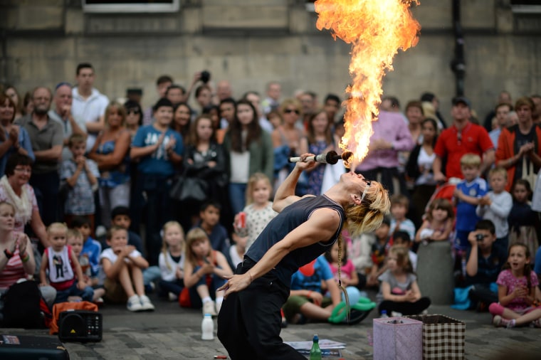Image: A street entertainer performs on Edinburgh's Royal Mile during the city's Festival Fringe.