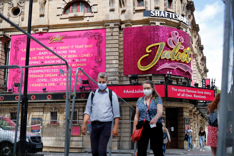 Image: Pedestrians walk past the Shaftesbury Theatre, which remains closed due to restrictions to slow the spread of the novel coronavirusm, in London's West End