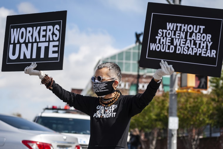 A car caravan protester shows solidarity with essential workers, who are put at risk every day with low pay and without necessary protective gear, outside a Whole Foods store in Brooklyn on May 1, 2020.
