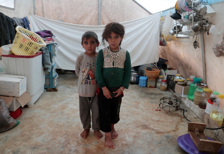 Image: Displaced Syrian twins from east Idlib, pose for a picture in a tent at Atmeh camp