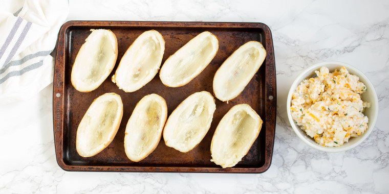 Scoop out the insides of each potato and place the insides into a mixing bowl.