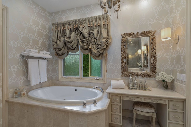 One of the seven bathrooms with ornate curtains and a matching mirror.