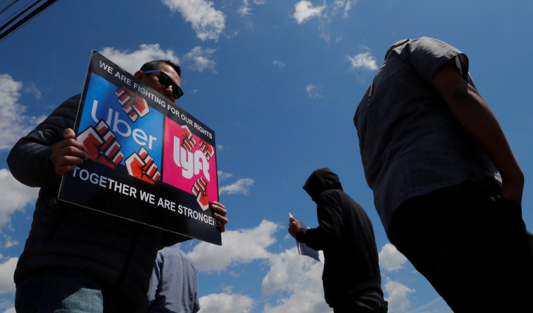 Uber and Lyft drivers protest during a day-long strike outside Uber's office in Saugus
