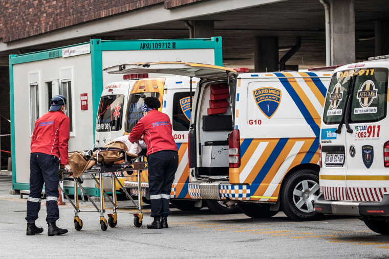 Image: Emergency paramedics wearing full COVID-19 coronavirus personal protective equipment (PPE) carry a patient from an ambulance at the Greenacres Hospital in Port Elizabeth