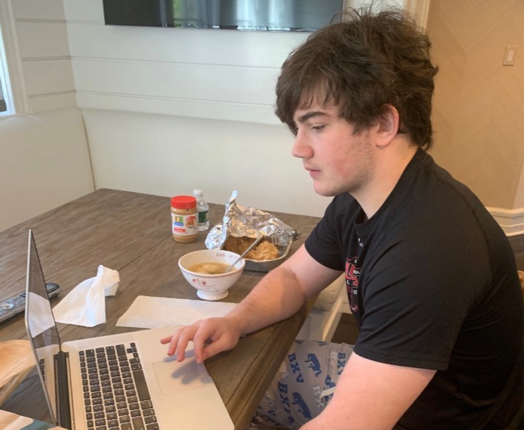 Kyle Glick, 16, working on his history homework in the kitchen while enjoying his grandmother's homemade matzo ball soup.