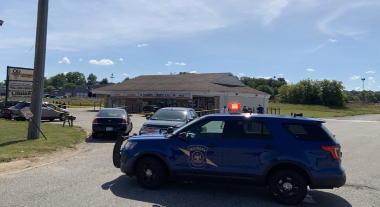 Officers with the Michigan State Police and Eaton County Sheriff's Department respond to a stabbing incident at a Quality Dairy store in Delta Township, Mich., on July 14, 2020.