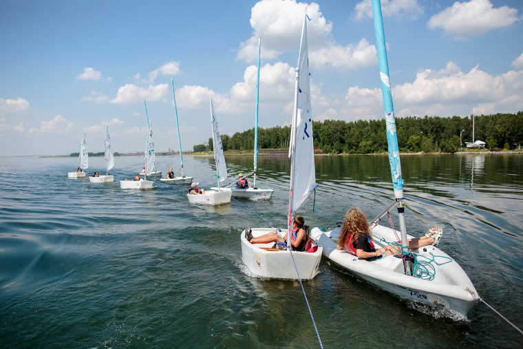 Image: Students of the Optimist children's sailing school take part in a training session in the Irkutsk water reservoir.