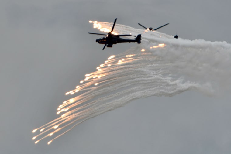Image: Two US-made AH-64E Apache attack helicopters release flares during the annual Han Kuang military drills in Taichung