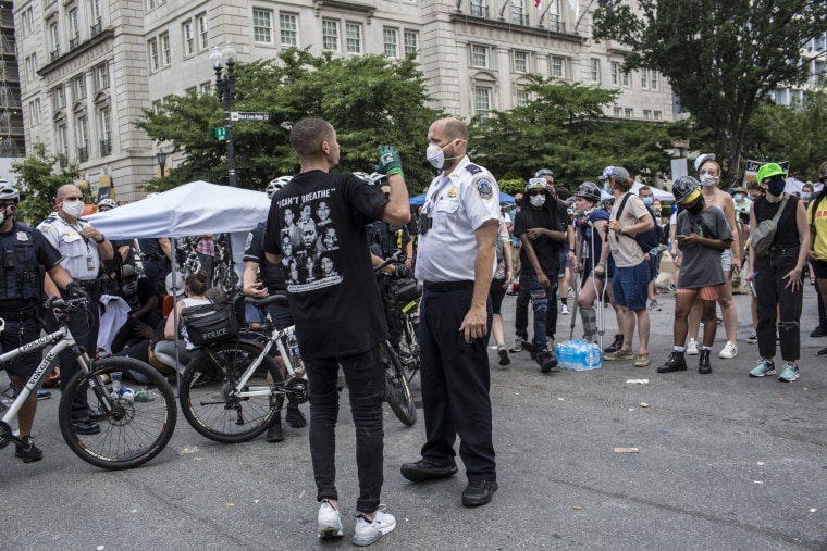 A demonstrator talks to a police officer at the Black Lives Matter Plaza near the White House on July 4, 2020.