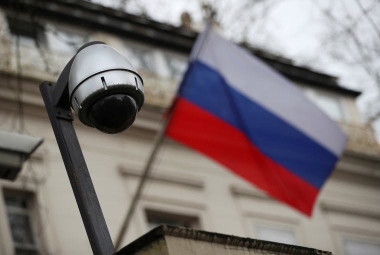 Image: A security camera and a flag flies outside the consular section of Russia's embassy in London, Britain.
