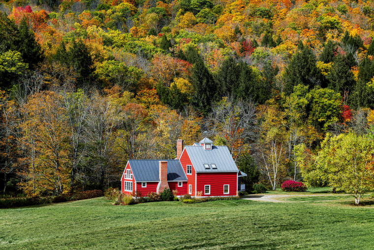 Charming red house flanked by autumn foliage