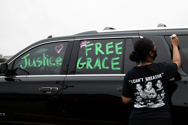 Robin Alford writes messages on her car at Groves High School in support of a Black fellow student.