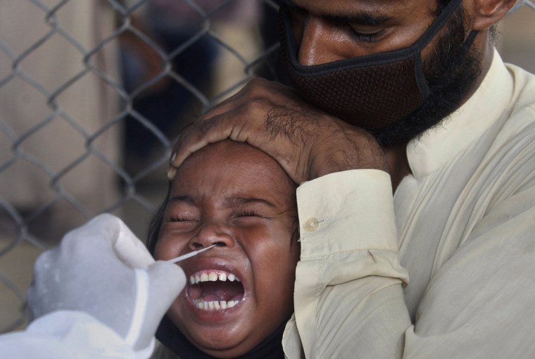 Image: A girl reacts while getting a nasal swab sample at a testing and screening facility for the new coronavirus in a hospital in Karachi, Pakistan