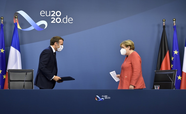 Image: German Chancellor Angela Merkel, right, and French President Emmanuel Macron prepare to address a media conference at the end of an EU summit