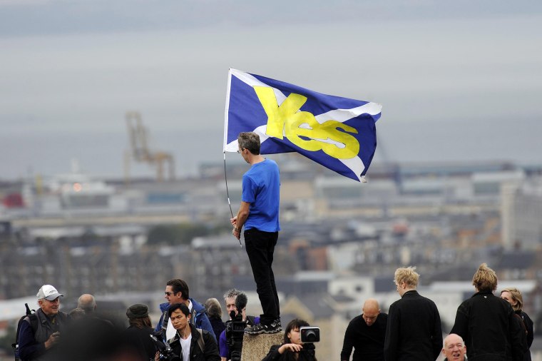 Image: A pro-independence supporter holds a Saltire flag with "Yes" written on it in Edinburgh on Sept. 21, 2013 during a march and rally in support of a yes vote in the Scottish Referendum