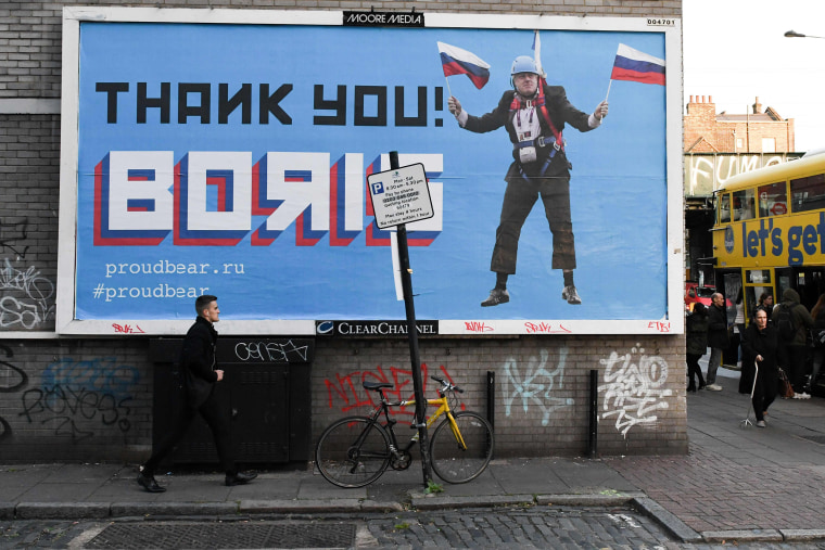 Image: A Brexit-themed billboard depicting Britain's former foreign secretary Boris Johnson waving Russian national flags reading "Thank you Boris" in east London
