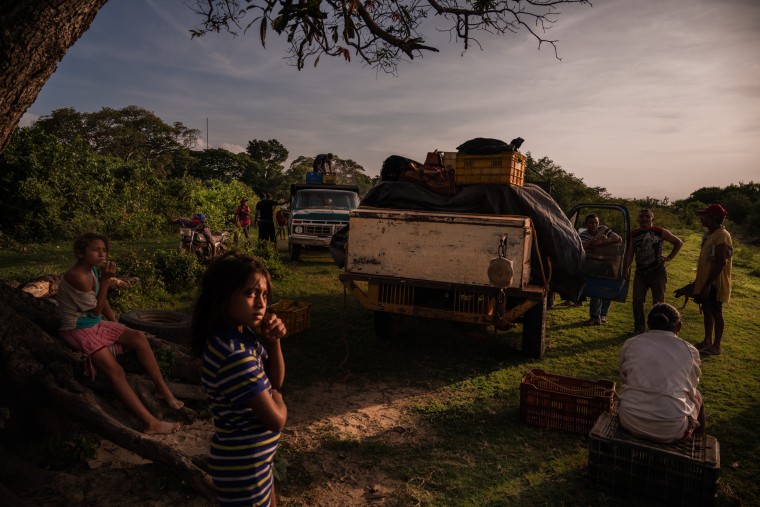 Mayerlin Barasalte and her sister wait for fishermen to return with the catch of the night.