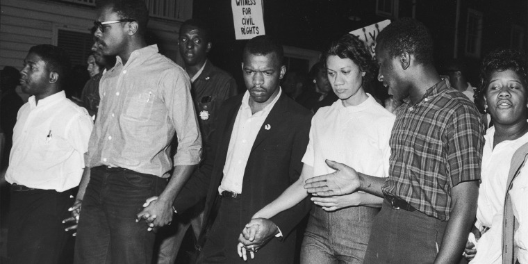 Civil rights leaders, including John Lewis, third from left, and Gloria Richardson, third from right, links hands with others as they march in protest of a scheduled speech by the pro-segregationist governor of Alabama, George Wallace, in Cambridge, Md., in May 1964.