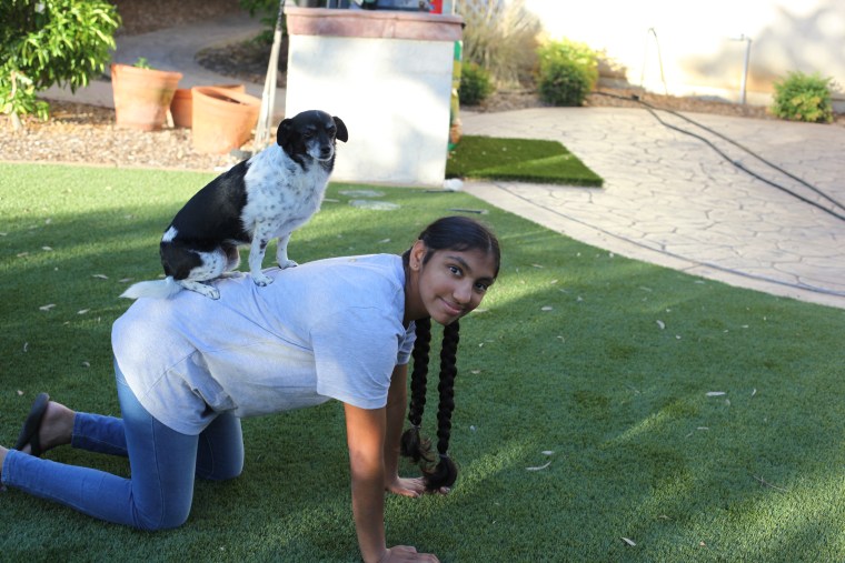 Meena Kumar's dog, Bambie, stands on her back.