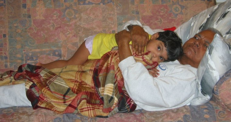 A young Meena Kumar snuggles with her grandfather.