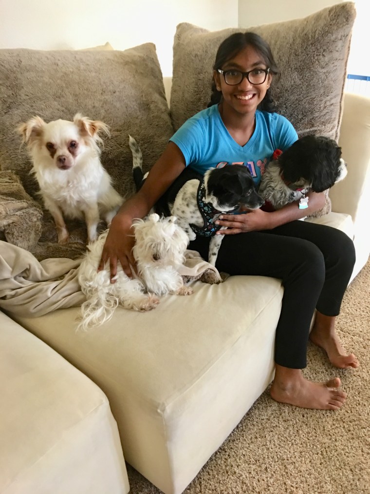 Meena Kumar smiles with senior dogs.