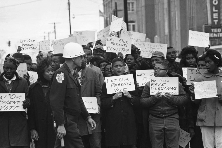 Image: Sign-carrying young African Americans sing and chant as they stage a demonstration at the courthouse