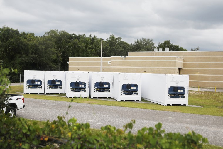 Image: Six refrigerator trailers sit outside of the Hillsborough County Medical Examiners Office in Tampa