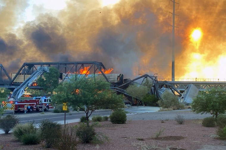 Smoke billows from a fire at the scene of a derailed train on the heavy rail bridge over Tempe Town Lake.