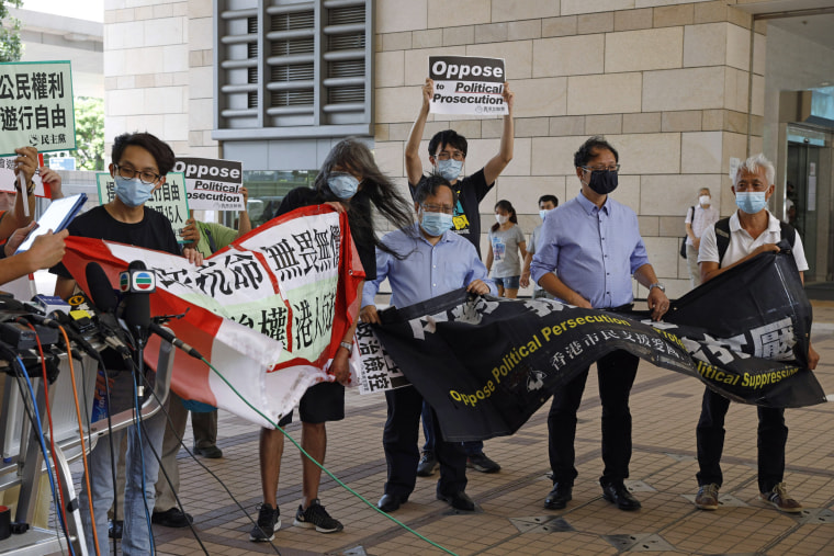 Image: Pro-democracy activists hold banners outside a court in Hong Kong on Thursday.