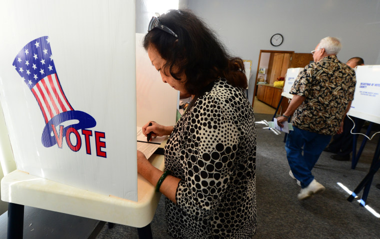 A woman votes at a polling station at St. Paul's Lutheran Church in Monterey Park, Los Angeles County