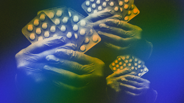 Image: Gloved hands hold hydroxychloroquine tablets.