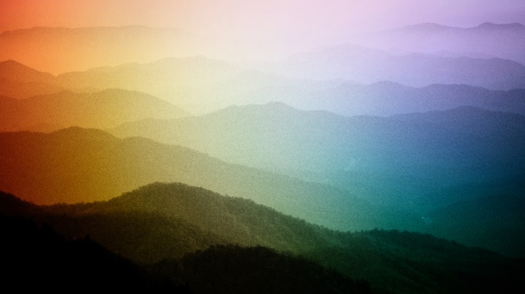 Image: Mist over the Blue Ridge Mountains, a segment of the Appalachian Mountains, in North Carolina with a color overlay of a rainbow pride flag.